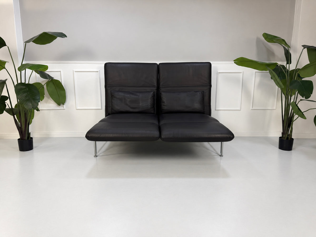 Gebrauchtes schwarzes Brühl Roro Medium Designer Leder Sofa vor einer Wand, stilvoll und modern eingerichtet.