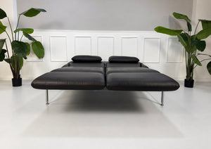 Gebrauchtes schwarzes Brühl Roro Medium Designer Leder Sofa vor einer Wand, stilvoll und modern eingerichtet.