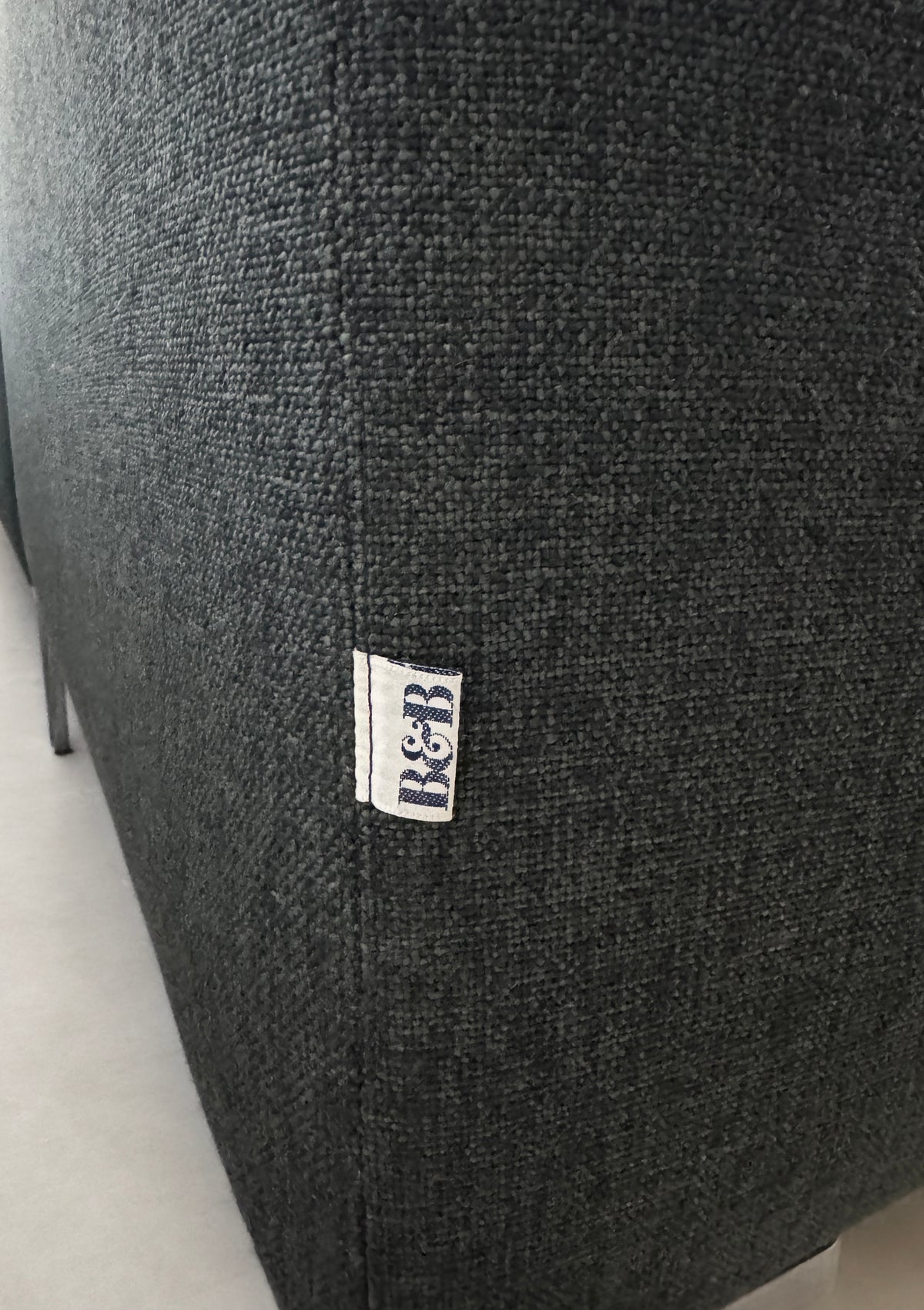Gebrauchtes graues B&B Italia Charles Designer Stoff Ecksofa vor einer Wand, stilvoll und modern eingerichtet.