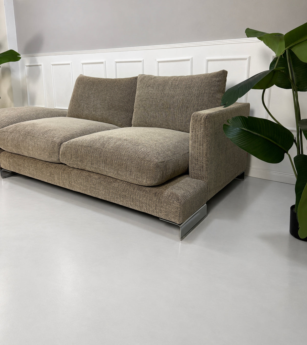 Gebrauchtes beiges Flexform Long Island 05 Designer Stoff Sofa mit Hocker vor einer Wand, stilvoll und modern eingerichtet.