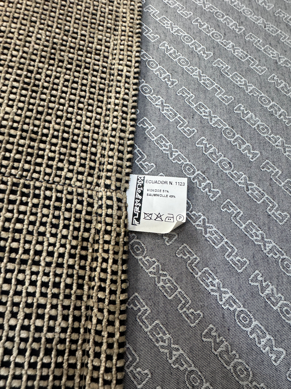 Gebrauchtes beiges Flexform Long Island 05 Designer Stoff Sofa mit Hocker vor einer Wand, stilvoll und modern eingerichtet.