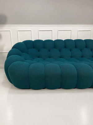 Gebrauchtes blaues Roche Bobois Bubble Designer Stoff Sofa vor einer Wand, stilvoll und modern eingerichtet.