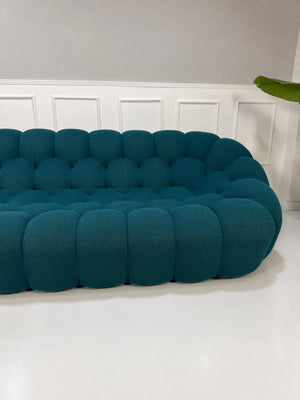 Gebrauchtes blaues Roche Bobois Bubble Designer Stoff Sofa vor einer Wand, stilvoll und modern eingerichtet.