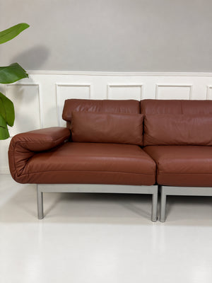Gebrauchtes braunes Rolf Benz Plura 380 Designer Leder Sofa vor einer Wand, stilvoll und modern eingerichtet.