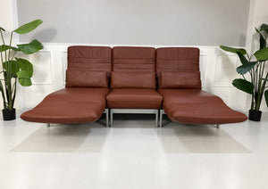Gebrauchtes braunes Rolf Benz Plura 380 Designer Leder Sofa vor einer Wand, stilvoll und modern eingerichtet.
