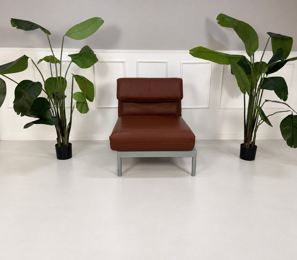 Gebrauchter brauner Rolf Benz Plura 380 Designer Leder Sessel vor einer Wand, stilvoll und modern eingerichtet.