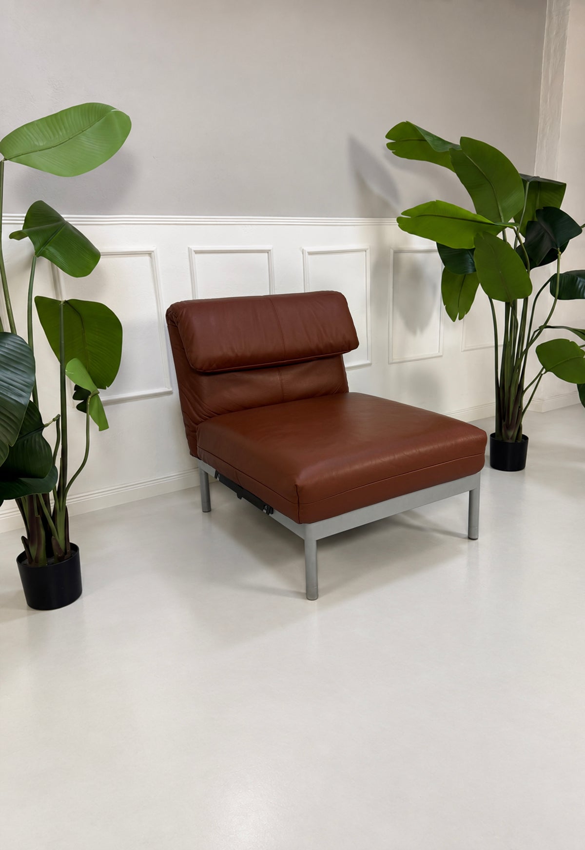 Gebrauchter brauner Rolf Benz Plura 380 Designer Leder Sessel vor einer Wand, stilvoll und modern eingerichtet.