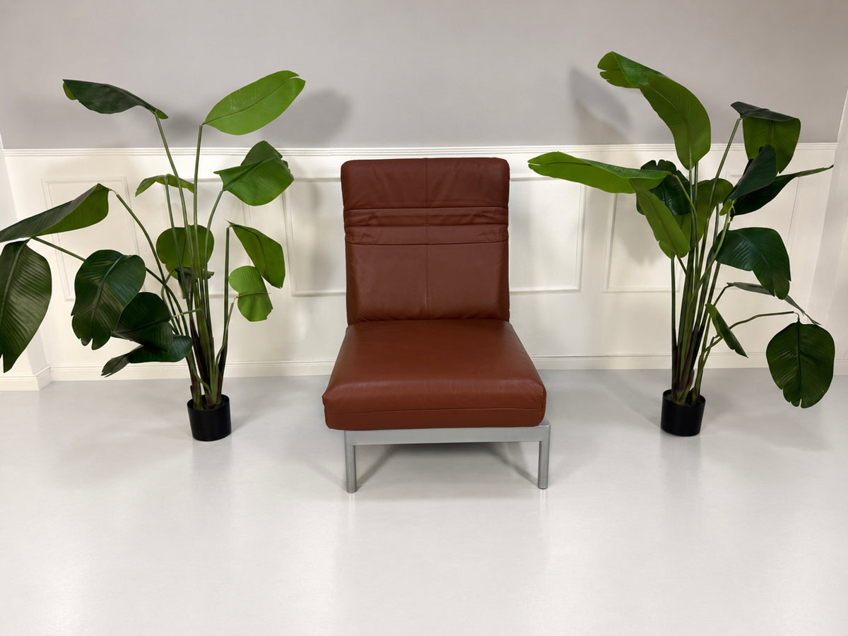 Gebrauchter brauner Rolf Benz Plura 380 Designer Leder Sessel vor einer Wand, stilvoll und modern eingerichtet.