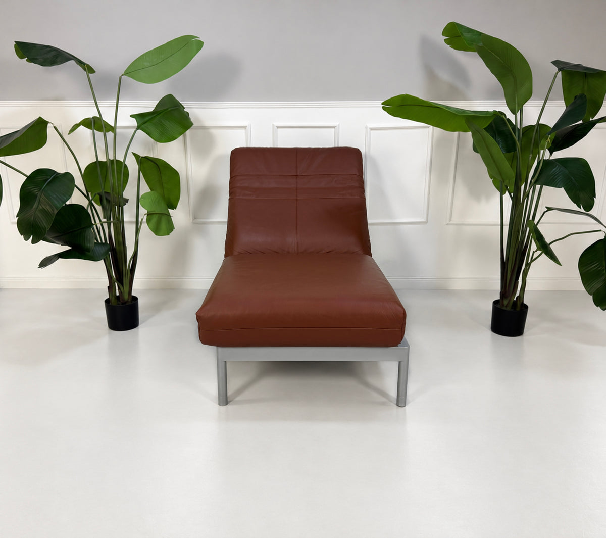 Gebrauchter brauner Rolf Benz Plura 380 Designer Leder Sessel vor einer Wand, stilvoll und modern eingerichtet.