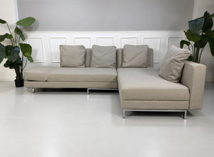 Gebrauchtes beiges Brühl Fourtwo Designer Stoff Ecksofa vor einer Wand, stilvoll und modern eingerichtet.