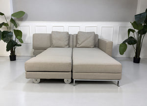 Gebrauchtes beiges Brühl Fourtwo Designer Stoff Ecksofa vor einer Wand, stilvoll und modern eingerichtet.