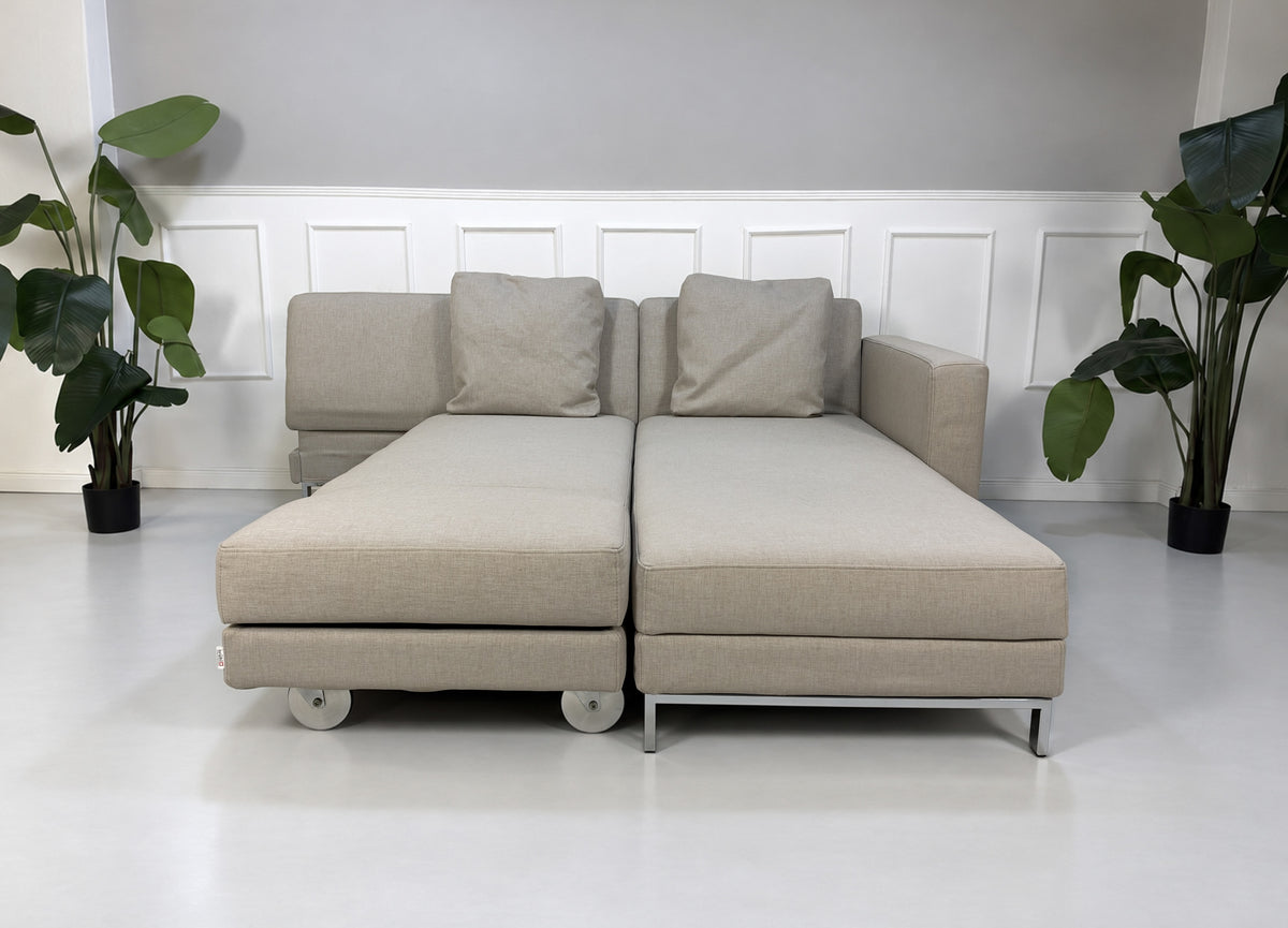 Gebrauchtes beiges Brühl Fourtwo Designer Stoff Ecksofa vor einer Wand, stilvoll und modern eingerichtet.