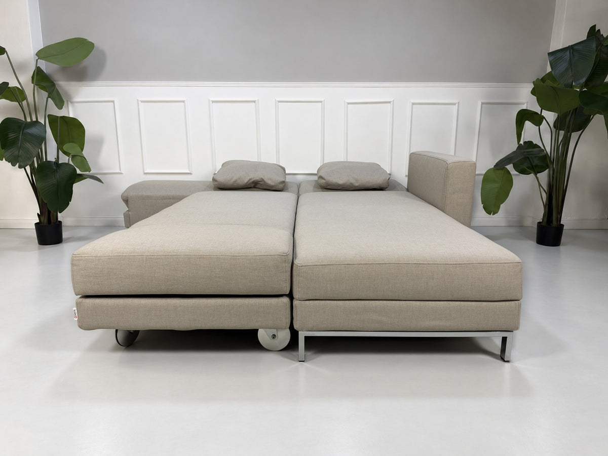 Gebrauchtes beiges Brühl Fourtwo Designer Stoff Ecksofa vor einer Wand, stilvoll und modern eingerichtet.
