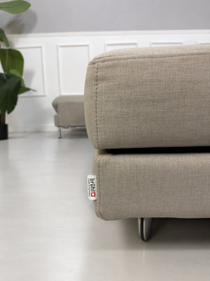 Gebrauchtes beiges Brühl Fourtwo Designer Stoff Ecksofa vor einer Wand, stilvoll und modern eingerichtet.