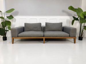 Gebrauchtes graues Flexform Lifewood Designer Stoff Sofa mit Love Chair vor einer Wand, stilvoll und modern eingerichtet.