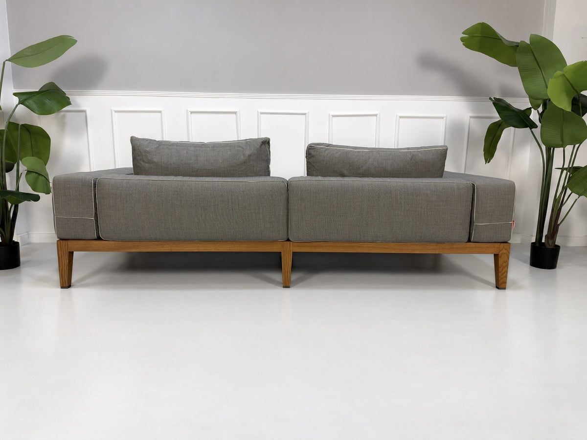 Gebrauchtes graues Flexform Lifewood Designer Stoff Sofa mit Love Chair vor einer Wand, stilvoll und modern eingerichtet.