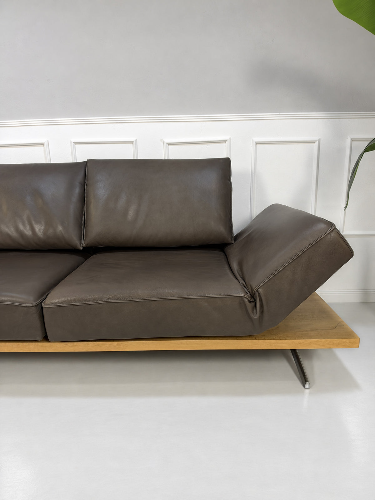 Gebrauchtes braunes Koinor Phoenix Designer Leder Sofa vor einer Wand, stilvoll und modern eingerichtet.