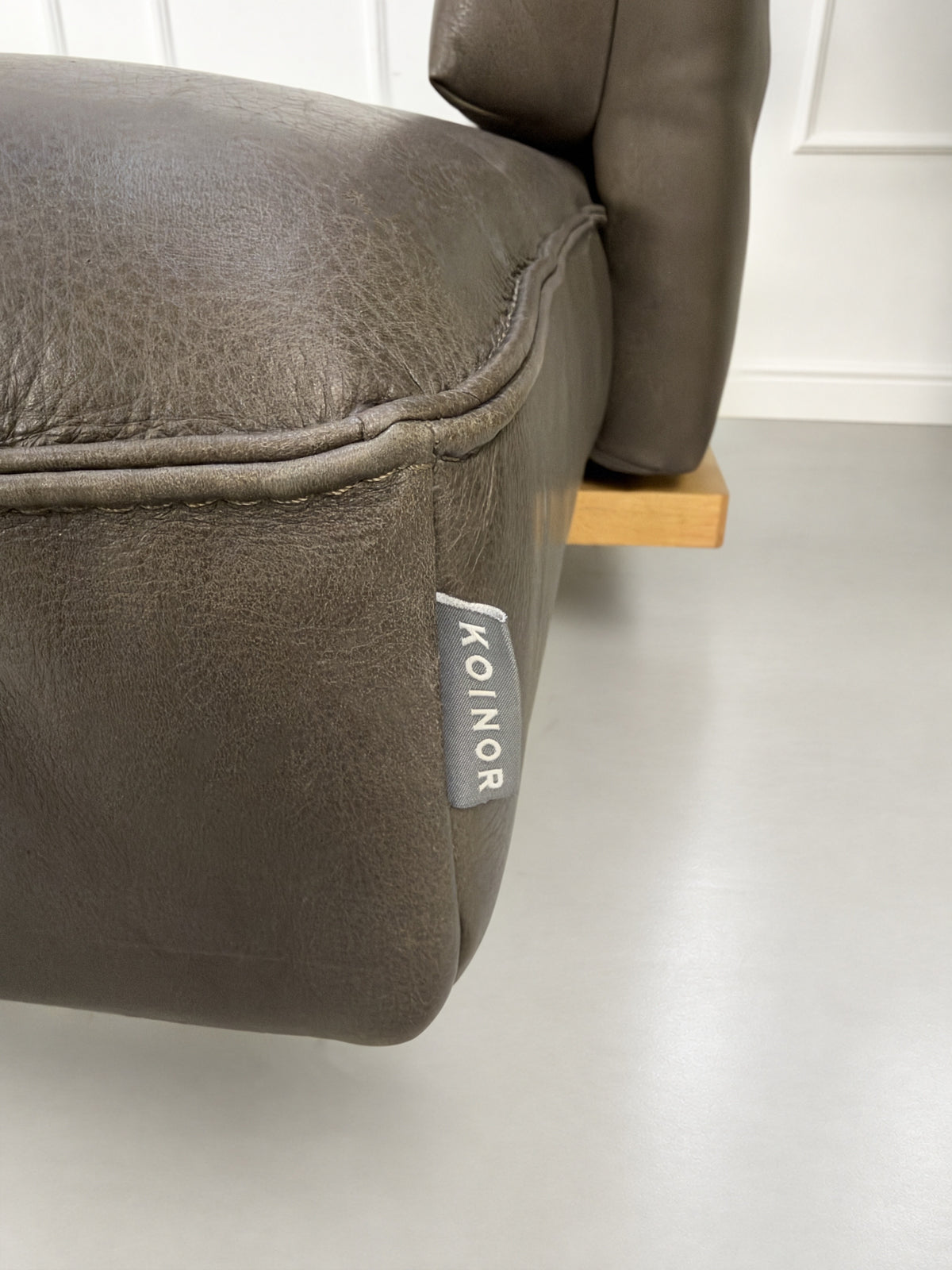 Gebrauchtes braunes Koinor Phoenix Designer Leder Sofa vor einer Wand, stilvoll und modern eingerichtet.