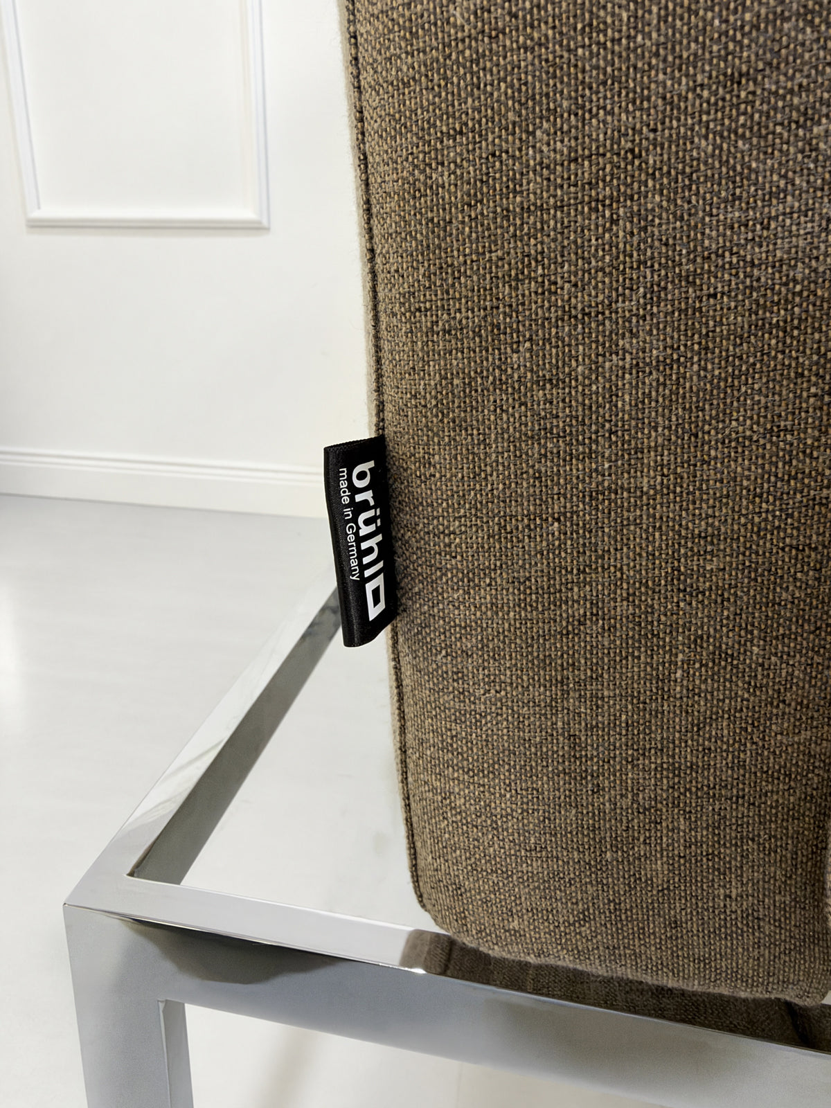 Gebrauchter grau-beiger Brühl Roro Medium Soft Designer Stoff Sessel vor einer Wand, stilvoll und modern eingerichtet.