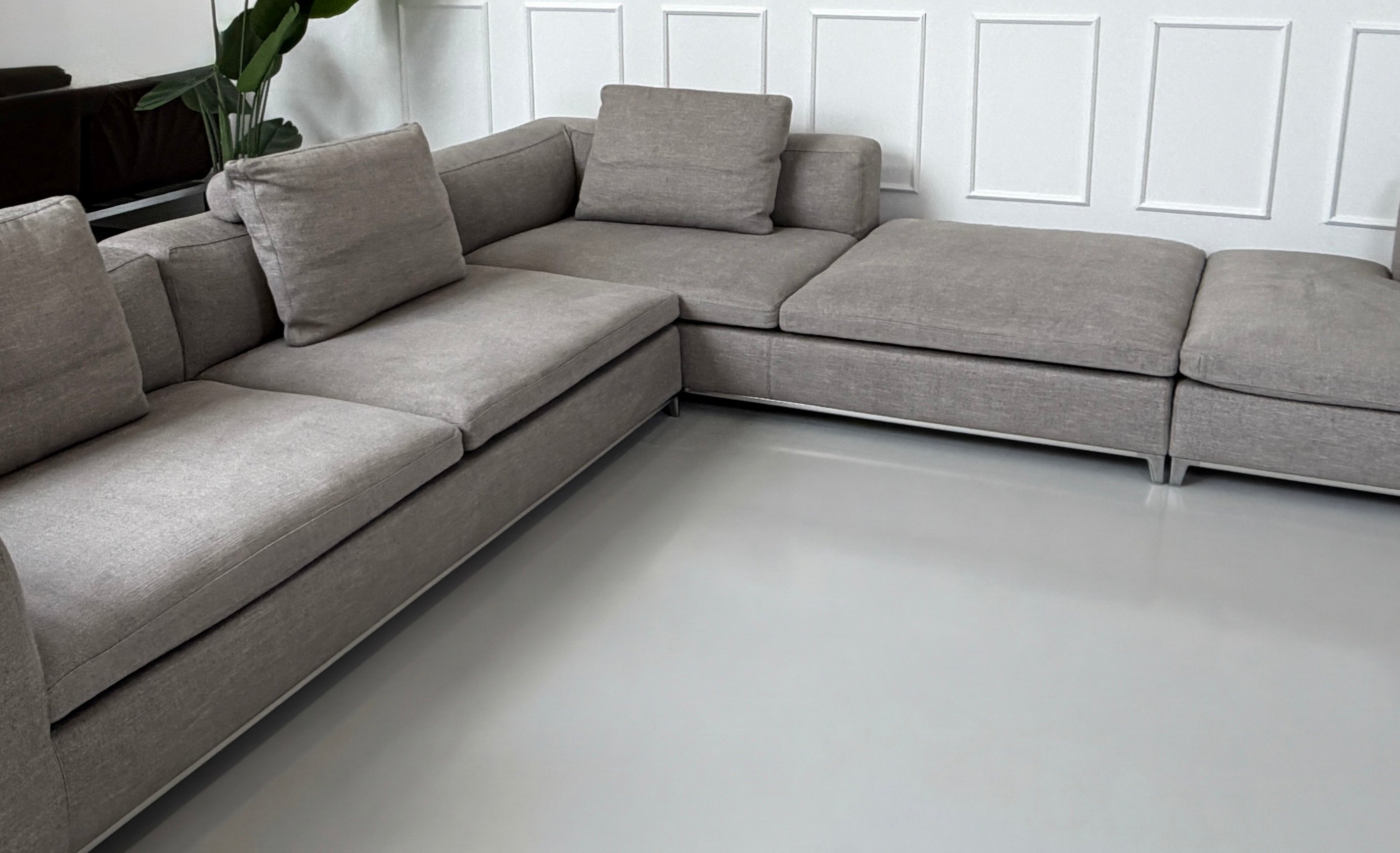 Gebrauchtes graues B&B Italia Michel Designer Stoff Sofa vor einer Wand, stilvoll und modern eingerichtet.