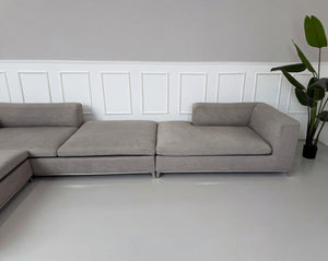 Gebrauchtes graues B&B Italia Michel Designer Stoff Sofa vor einer Wand, stilvoll und modern eingerichtet.
