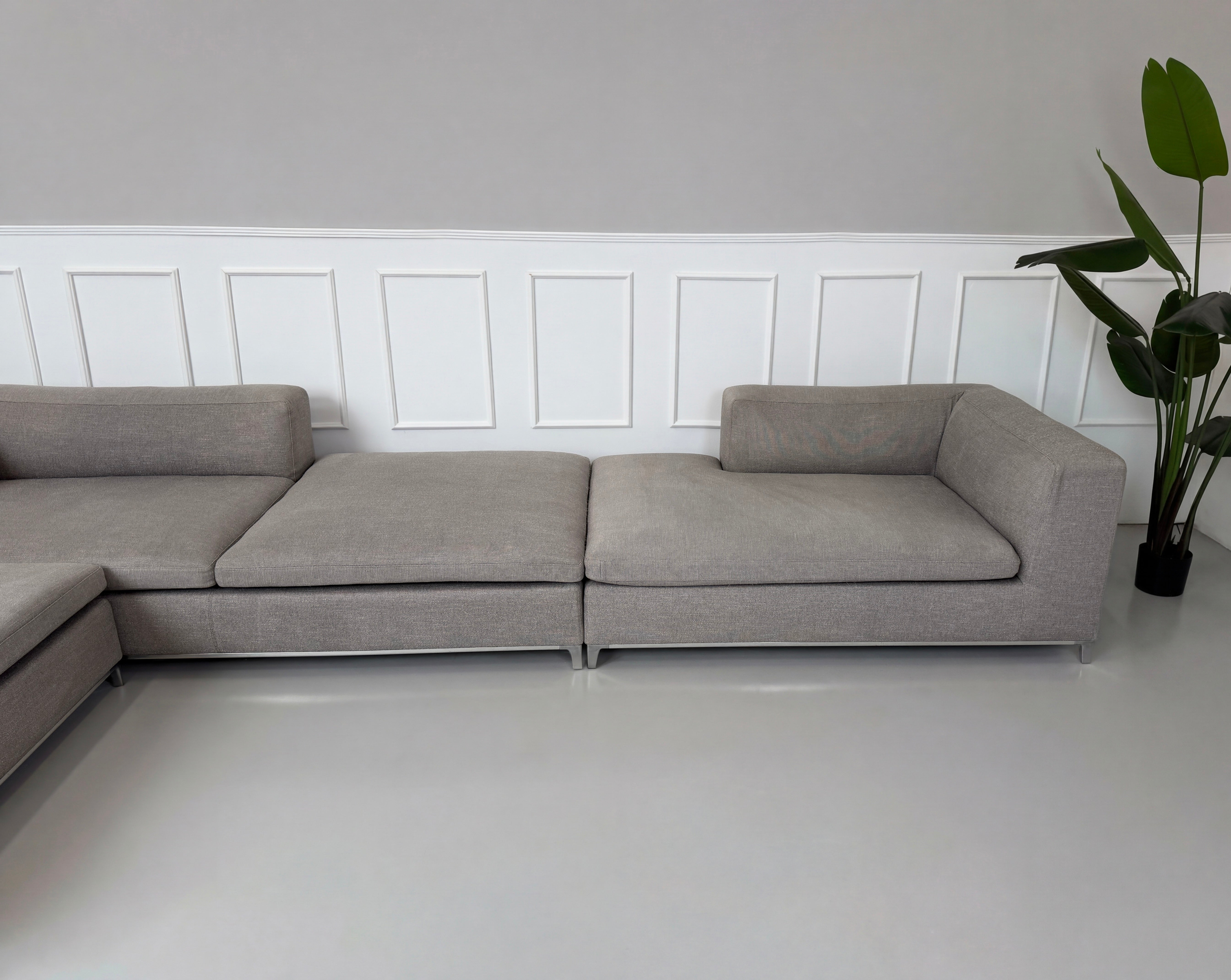 Gebrauchtes graues B&B Italia Michel Designer Stoff Sofa vor einer Wand, stilvoll und modern eingerichtet.