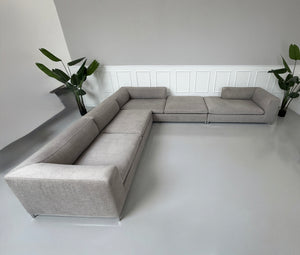 Gebrauchtes graues B&B Italia Michel Designer Stoff Sofa vor einer Wand, stilvoll und modern eingerichtet.