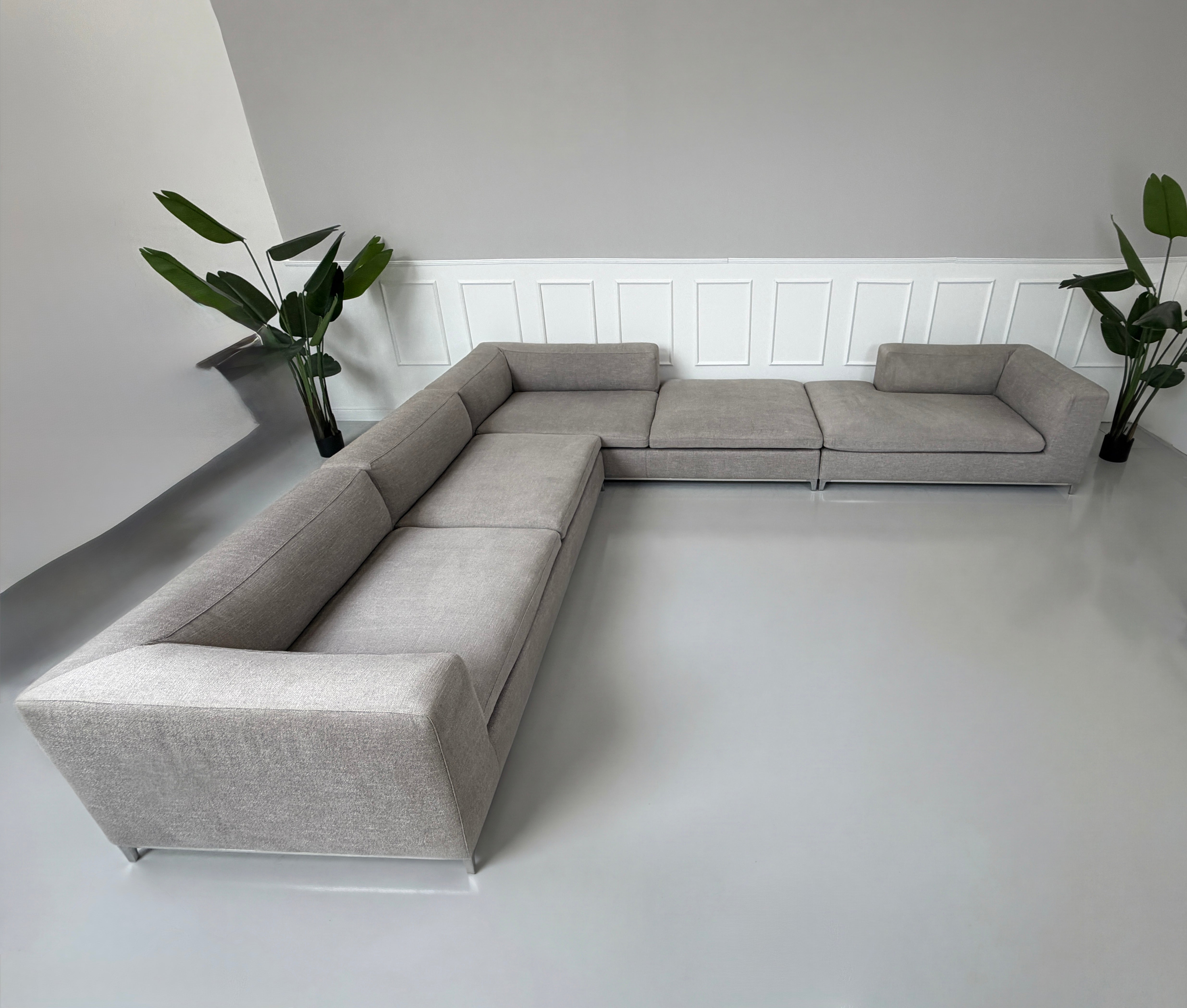 Gebrauchtes graues B&B Italia Michel Designer Stoff Sofa vor einer Wand, stilvoll und modern eingerichtet.