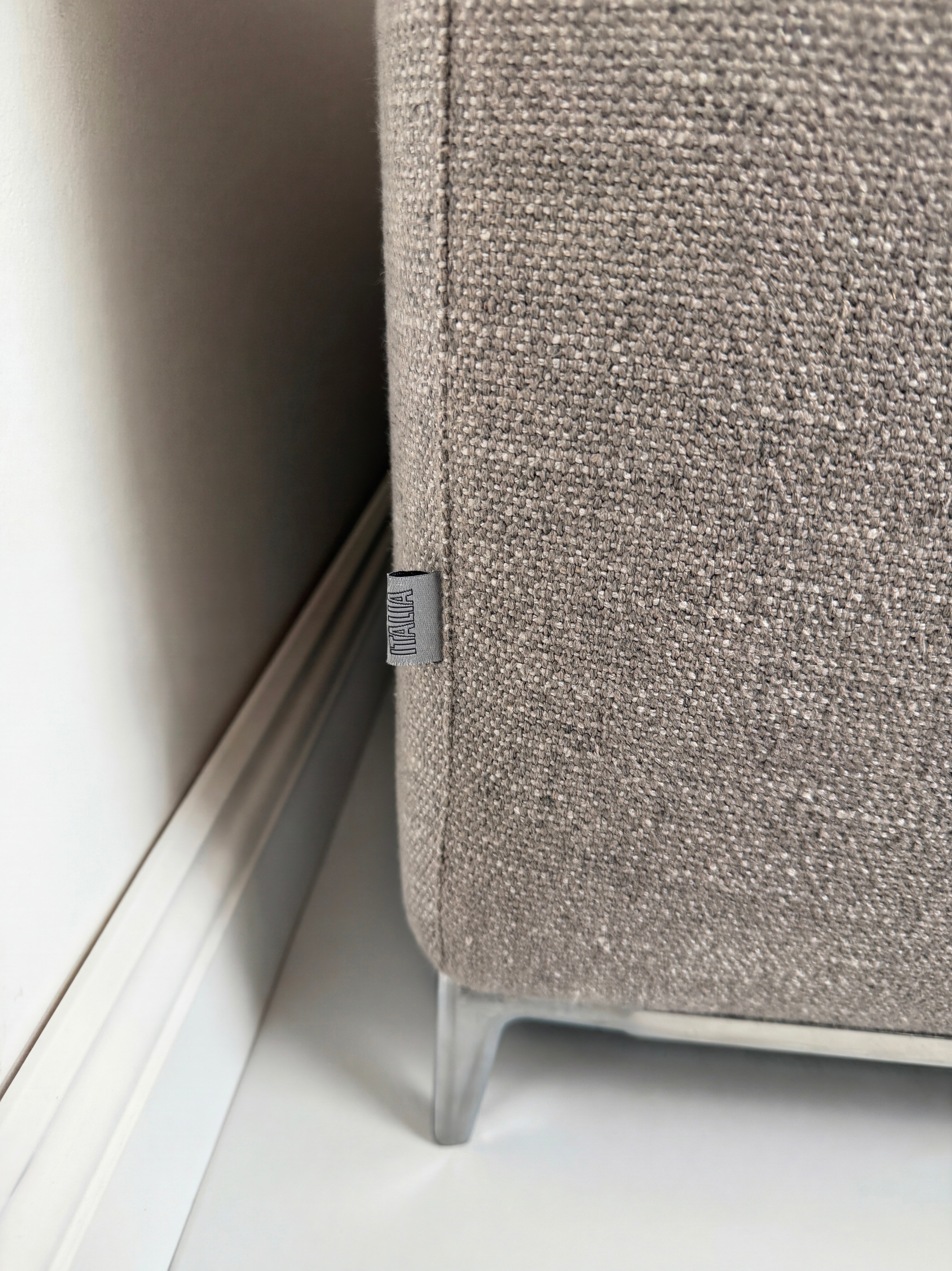 Gebrauchtes graues B&B Italia Michel Designer Stoff Sofa vor einer Wand, stilvoll und modern eingerichtet.