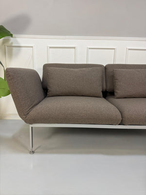 Gebrauchtes braunes Brühl Roro Designer Stoff Sofa vor einer Wand, stilvoll und modern eingerichtet.