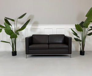 Gebrauchtes braunes Walter Knoll Foster Designer Leder Sofa vor einer Wand, stilvoll und modern eingerichtet.
