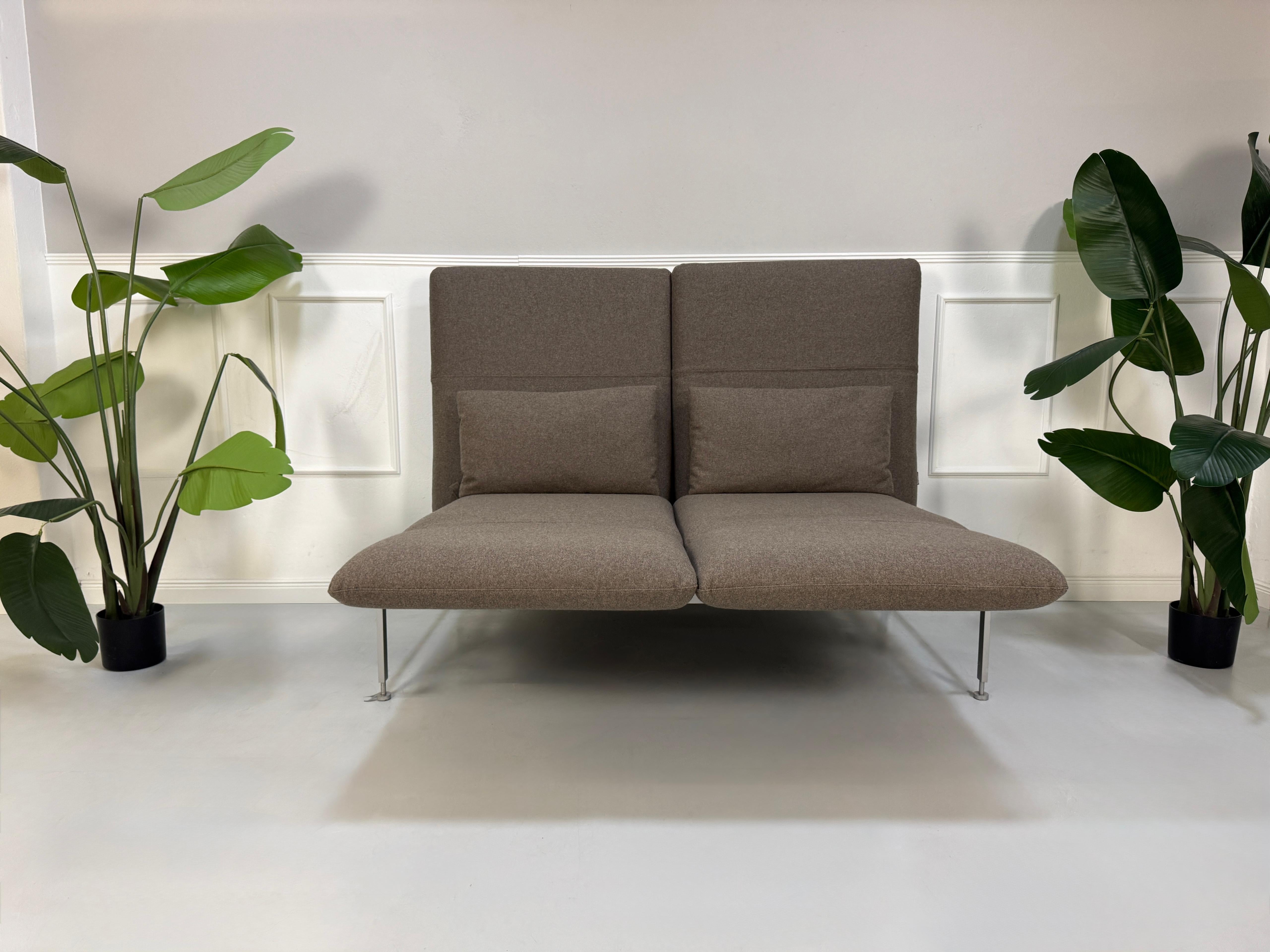 Gebrauchtes braunes Brühl Roro Designer Stoff Sofa vor einer Wand, stilvoll und modern eingerichtet.