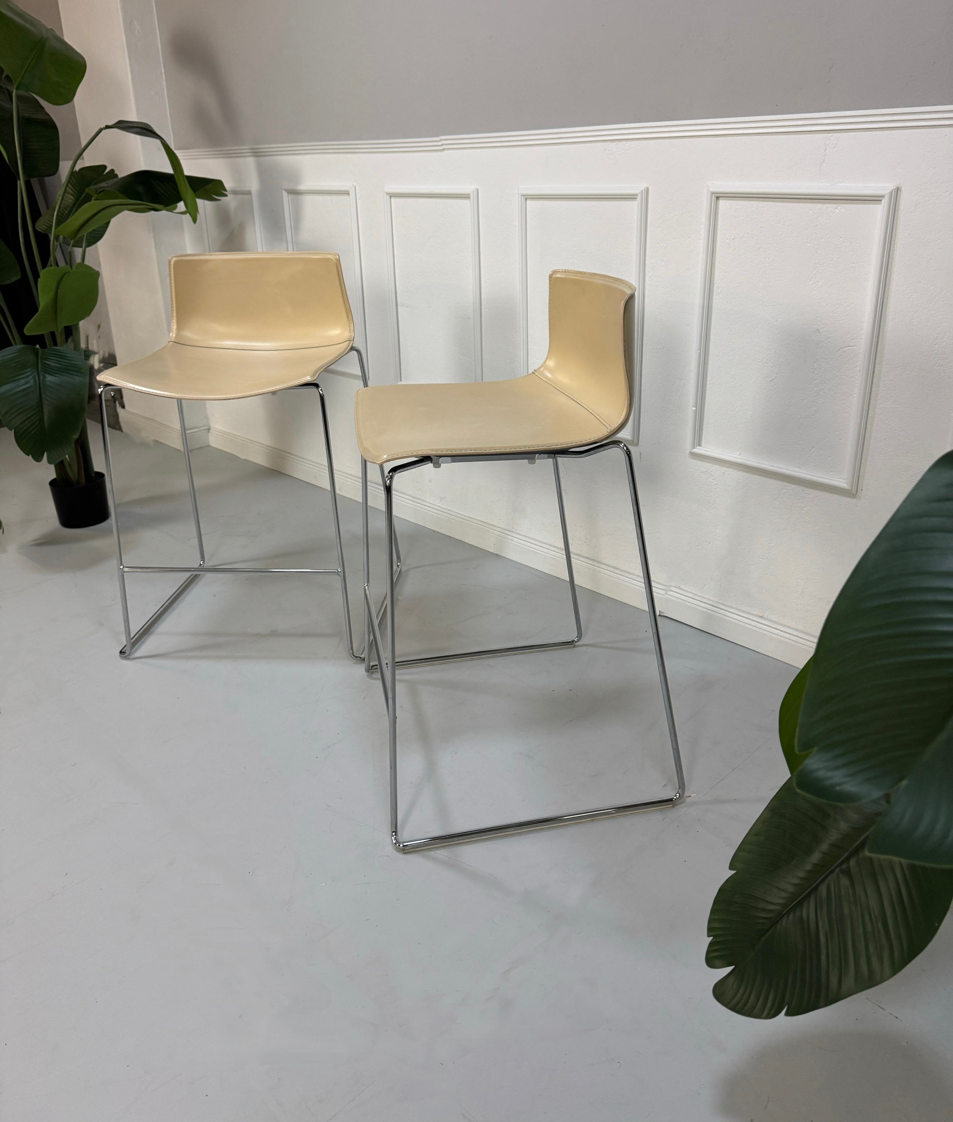 Gebrauchte beige Arper Catifa Designer Leder Stühle Barhocker vor einer Wand, stilvoll und modern eingerichtet.