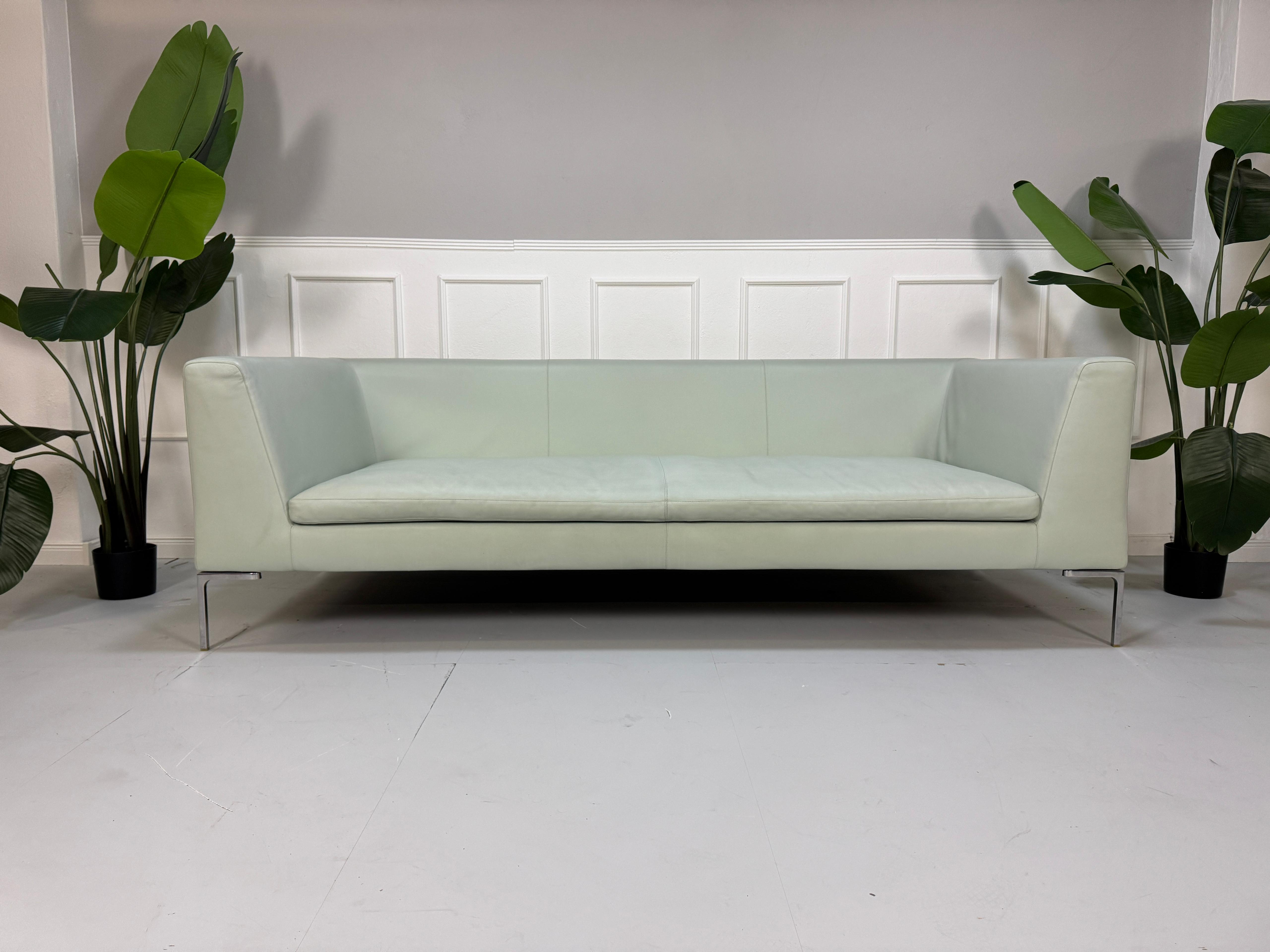 Gebrauchtes grünes B&B Italia Charles Designer Leder Sofa vor einer Wand, stilvoll und modern eingerichtet.