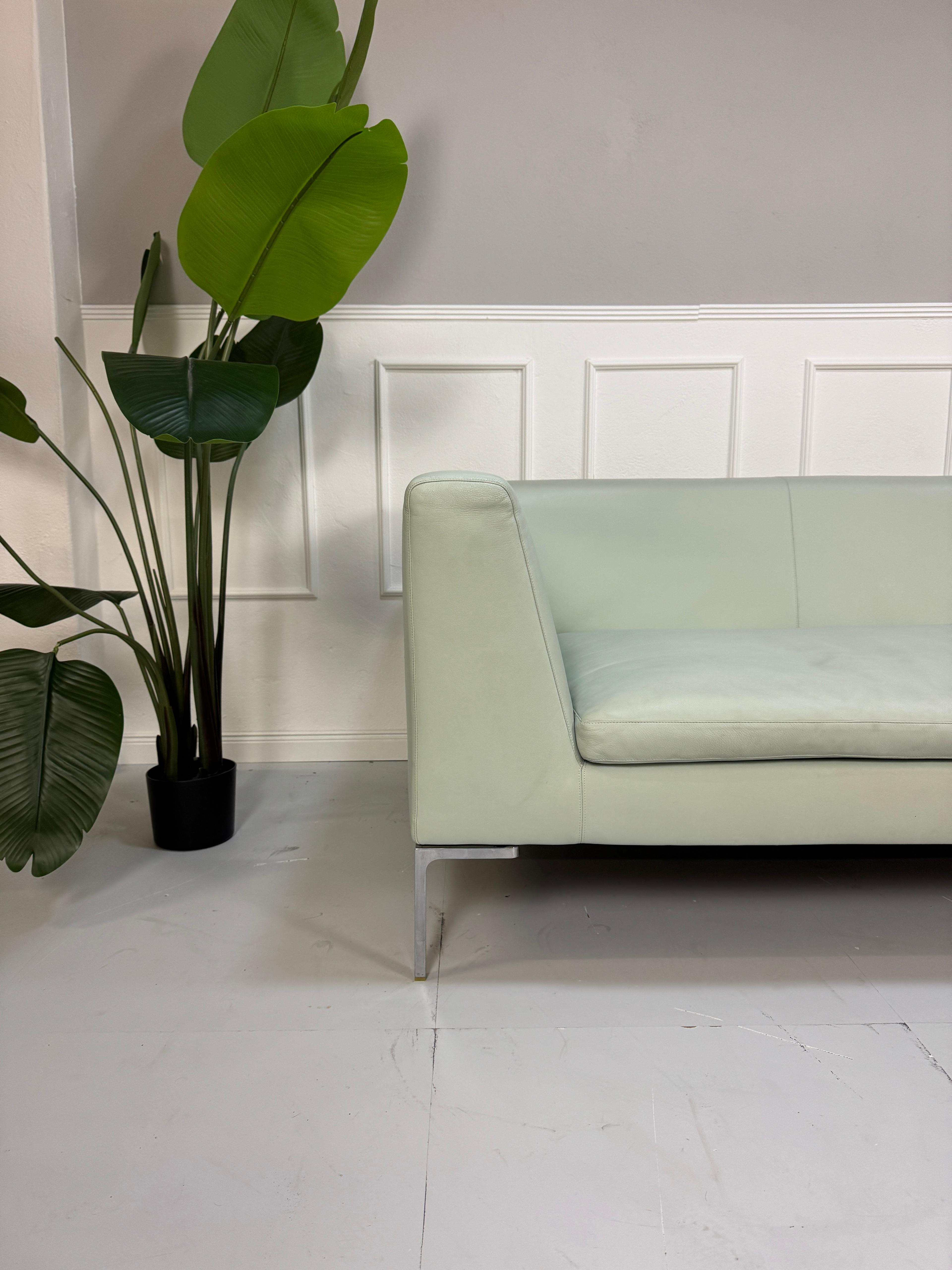 Gebrauchtes grünes B&B Italia Charles Designer Leder Sofa vor einer Wand, stilvoll und modern eingerichtet.