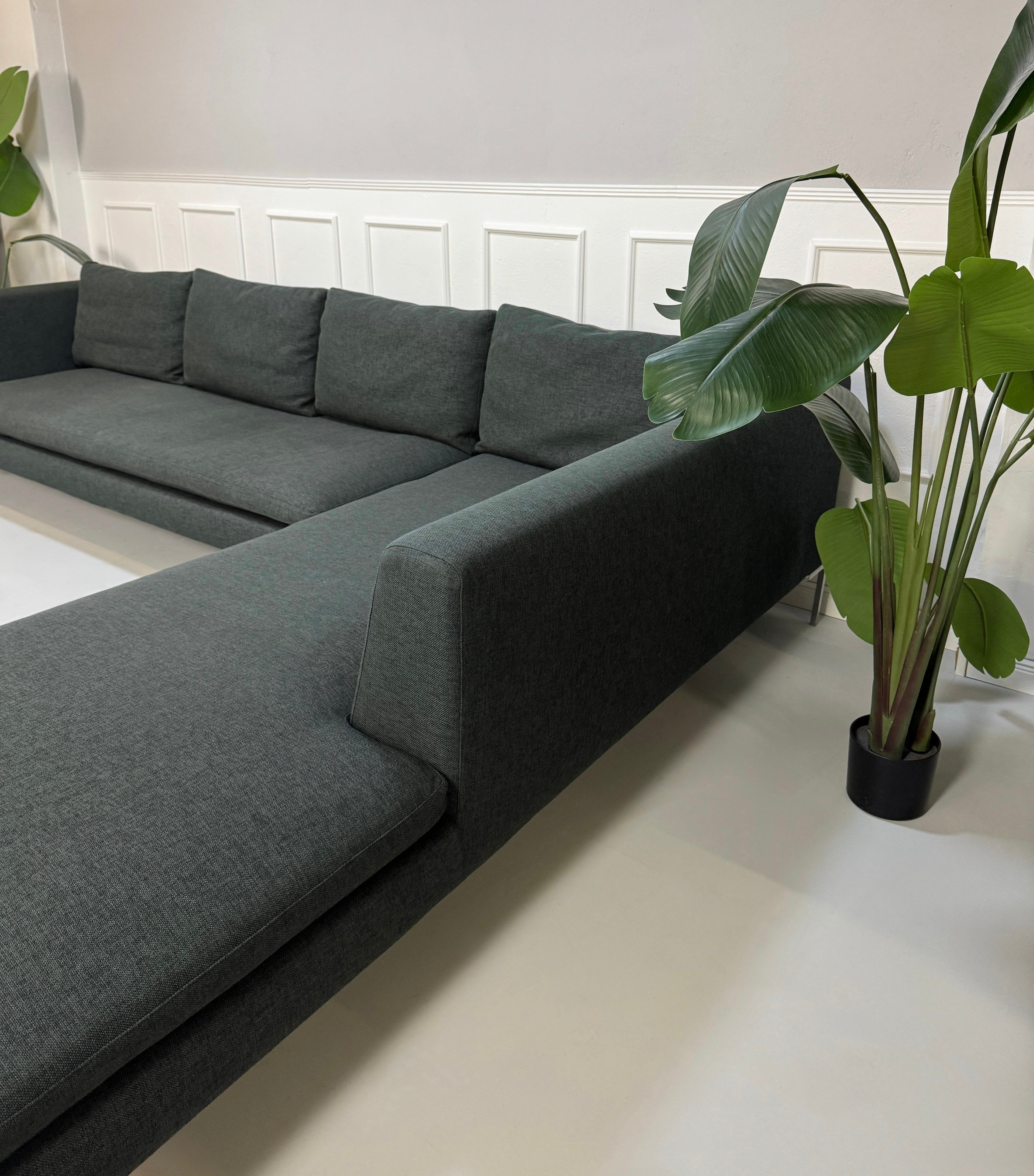 Gebrauchtes graues B&B Italia Charles Designer Stoff Sofa vor einer Wand, stilvoll und modern eingerichtet.