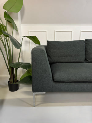 Gebrauchtes graues B&B Italia Charles Designer Stoff Sofa vor einer Wand, stilvoll und modern eingerichtet.
