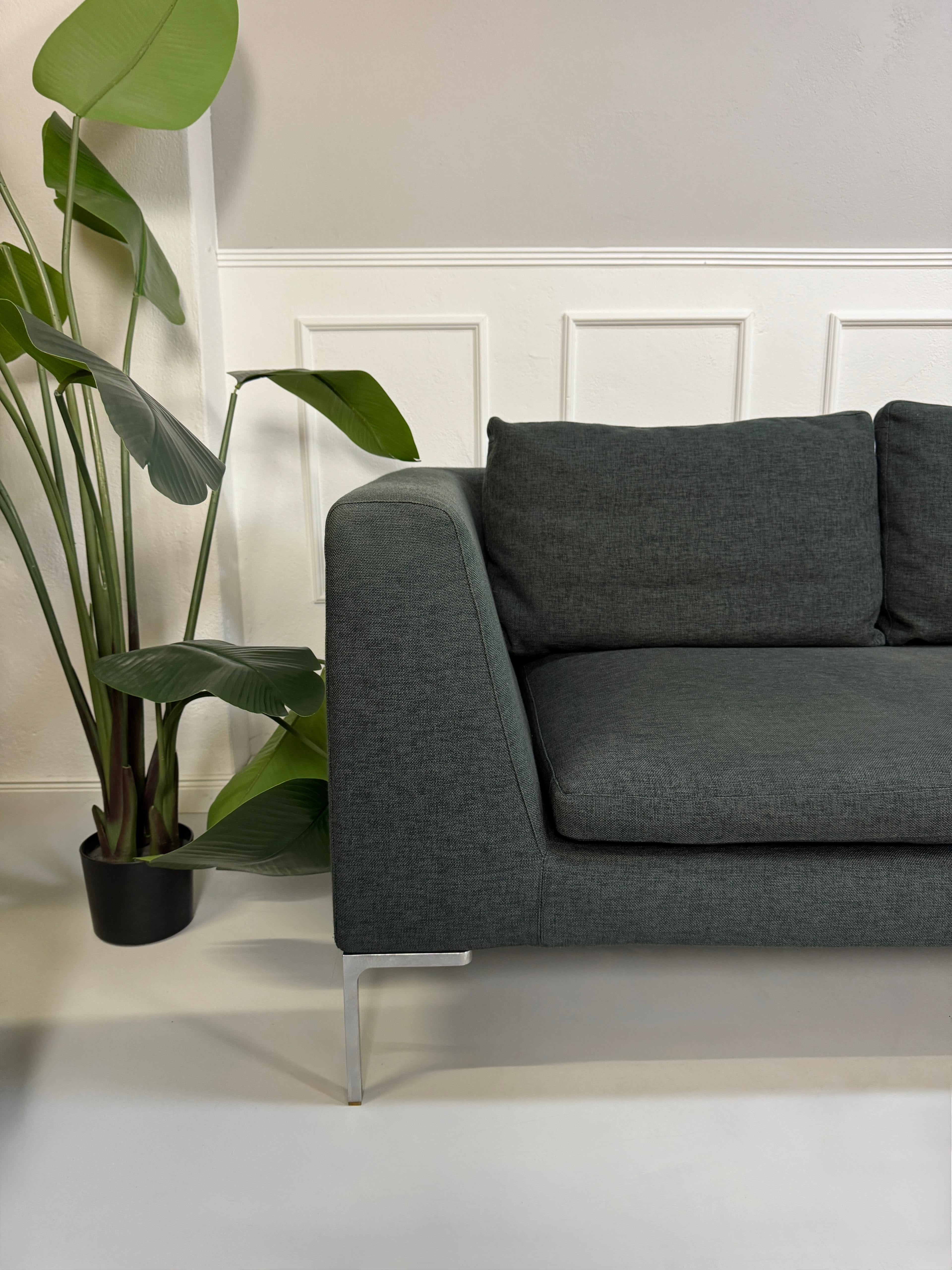 Gebrauchtes graues B&B Italia Charles Designer Stoff Sofa vor einer Wand, stilvoll und modern eingerichtet.