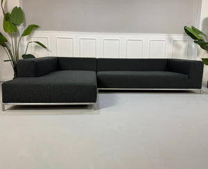 Gebrauchtes blaues B&B Italia George Designer Stoff Sofa vor einer Wand, stilvoll und modern eingerichtet.