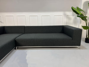 Gebrauchtes blaues B&B Italia George Designer Stoff Sofa vor einer Wand, stilvoll und modern eingerichtet.