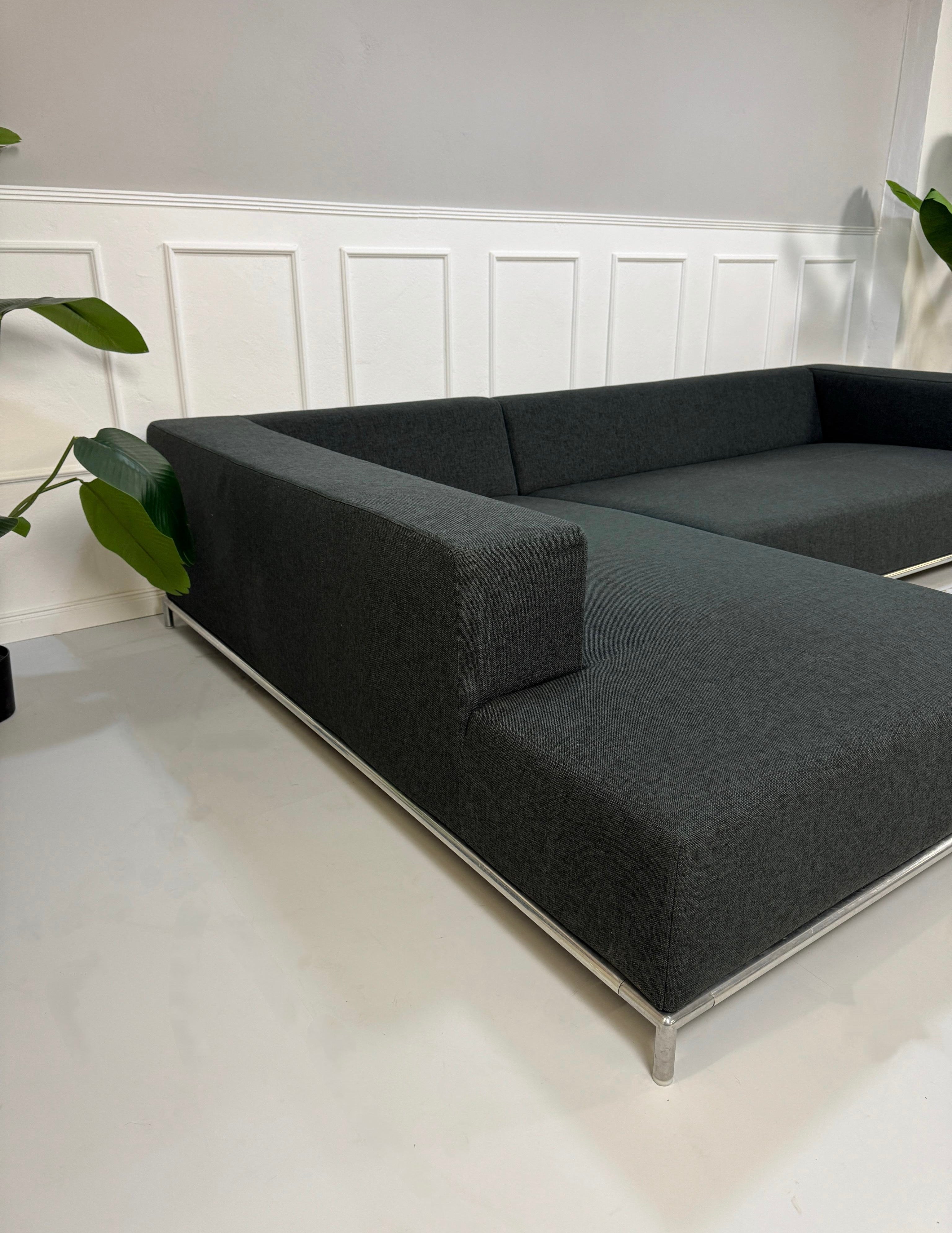 Gebrauchtes blaues B&B Italia George Designer Stoff Sofa vor einer Wand, stilvoll und modern eingerichtet.