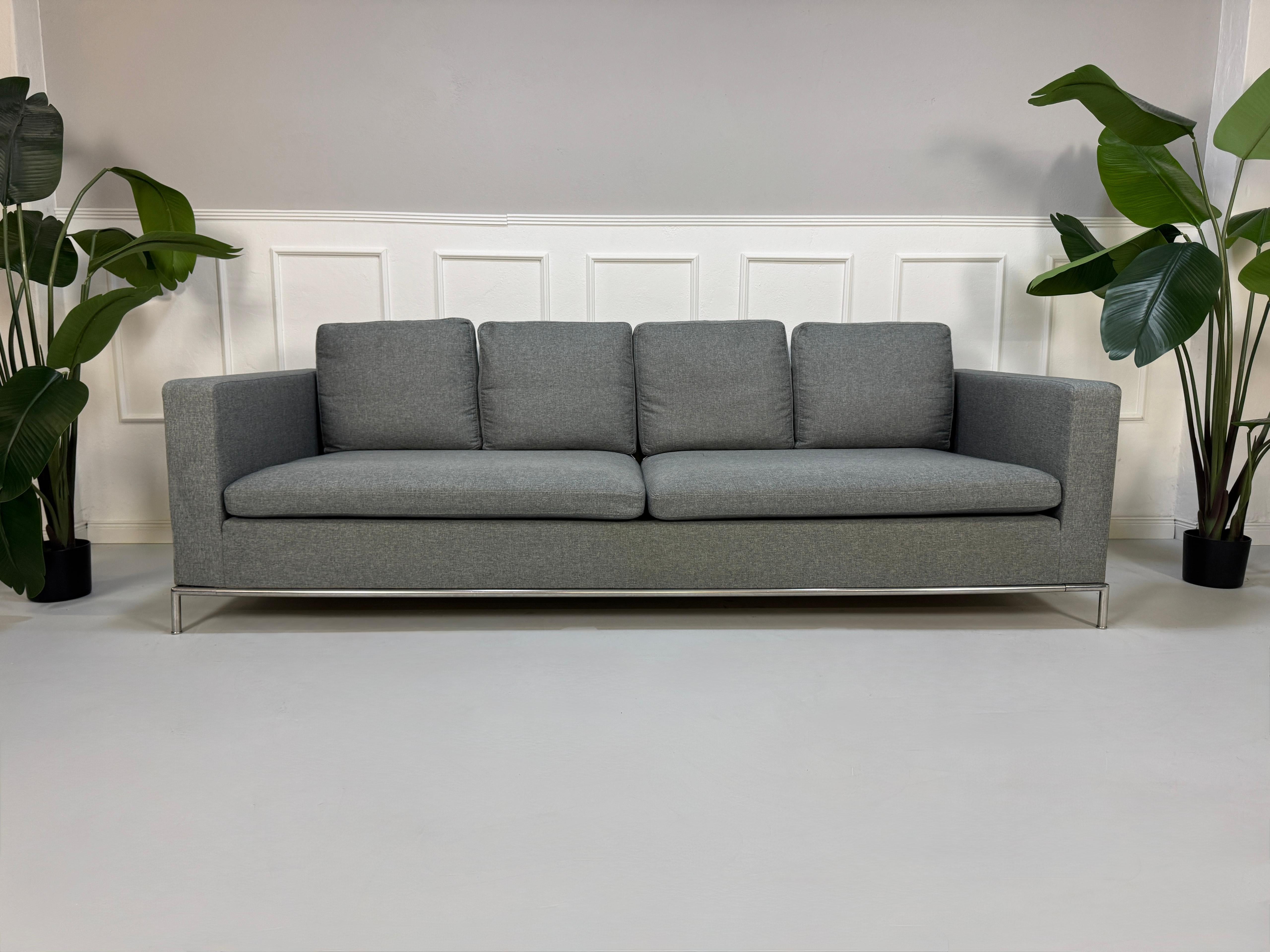 Gebrauchtes graues B&B Italia George Designer Stoff Sofa vor einer Wand, stilvoll und modern eingerichtet.