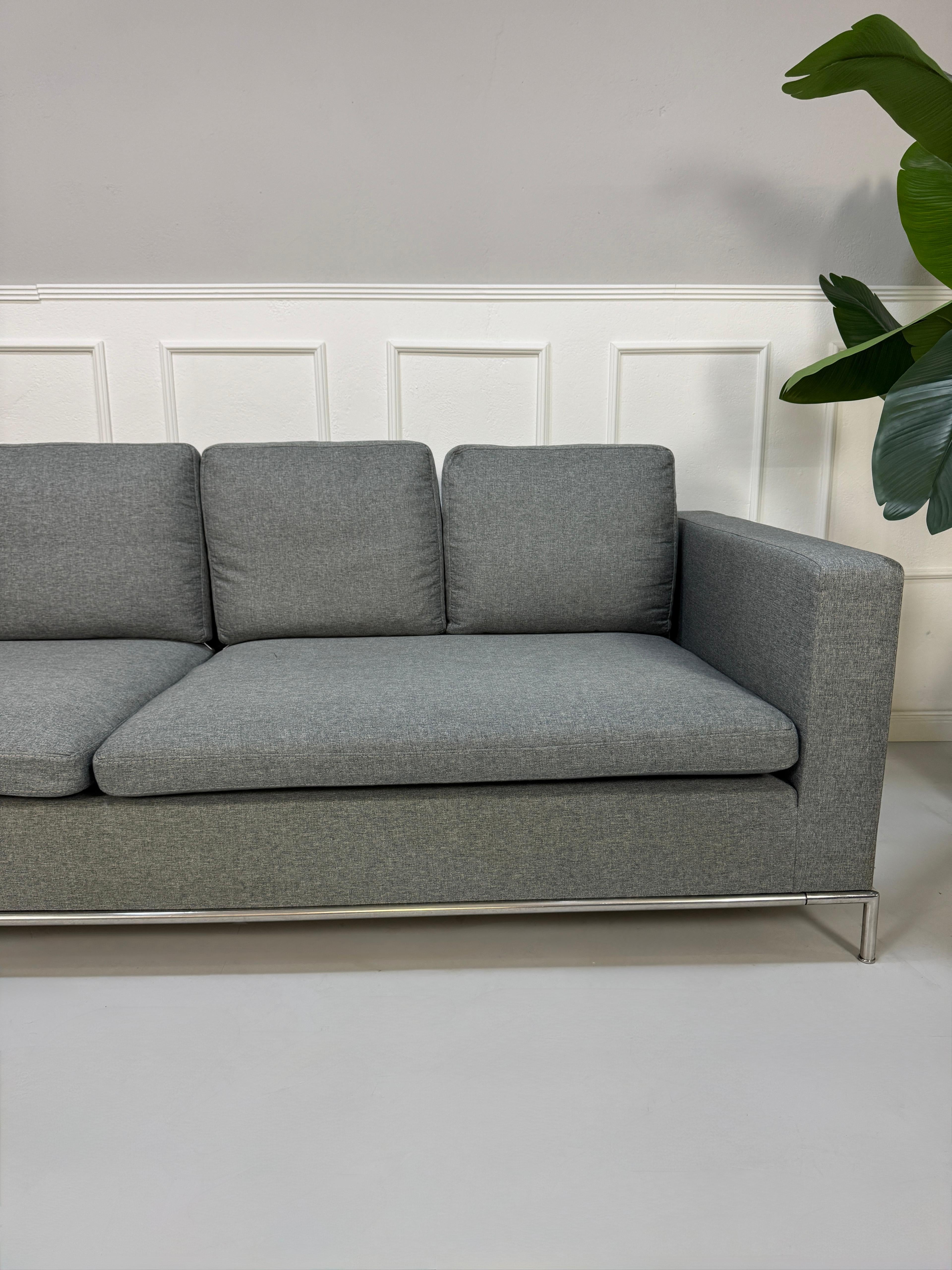 Gebrauchtes graues B&B Italia George Designer Stoff Sofa vor einer Wand, stilvoll und modern eingerichtet.