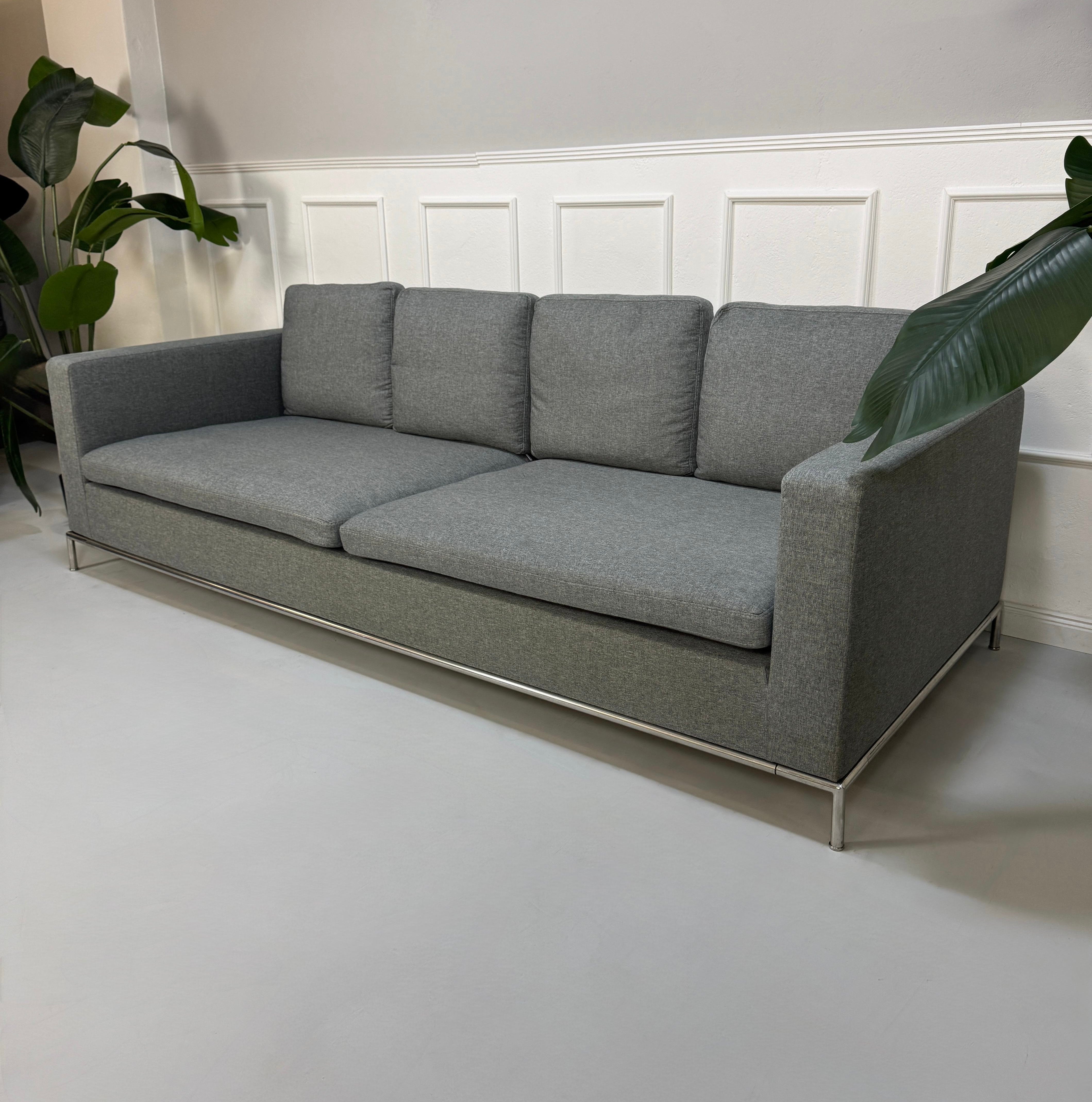 Gebrauchtes graues B&B Italia George Designer Stoff Sofa vor einer Wand, stilvoll und modern eingerichtet.