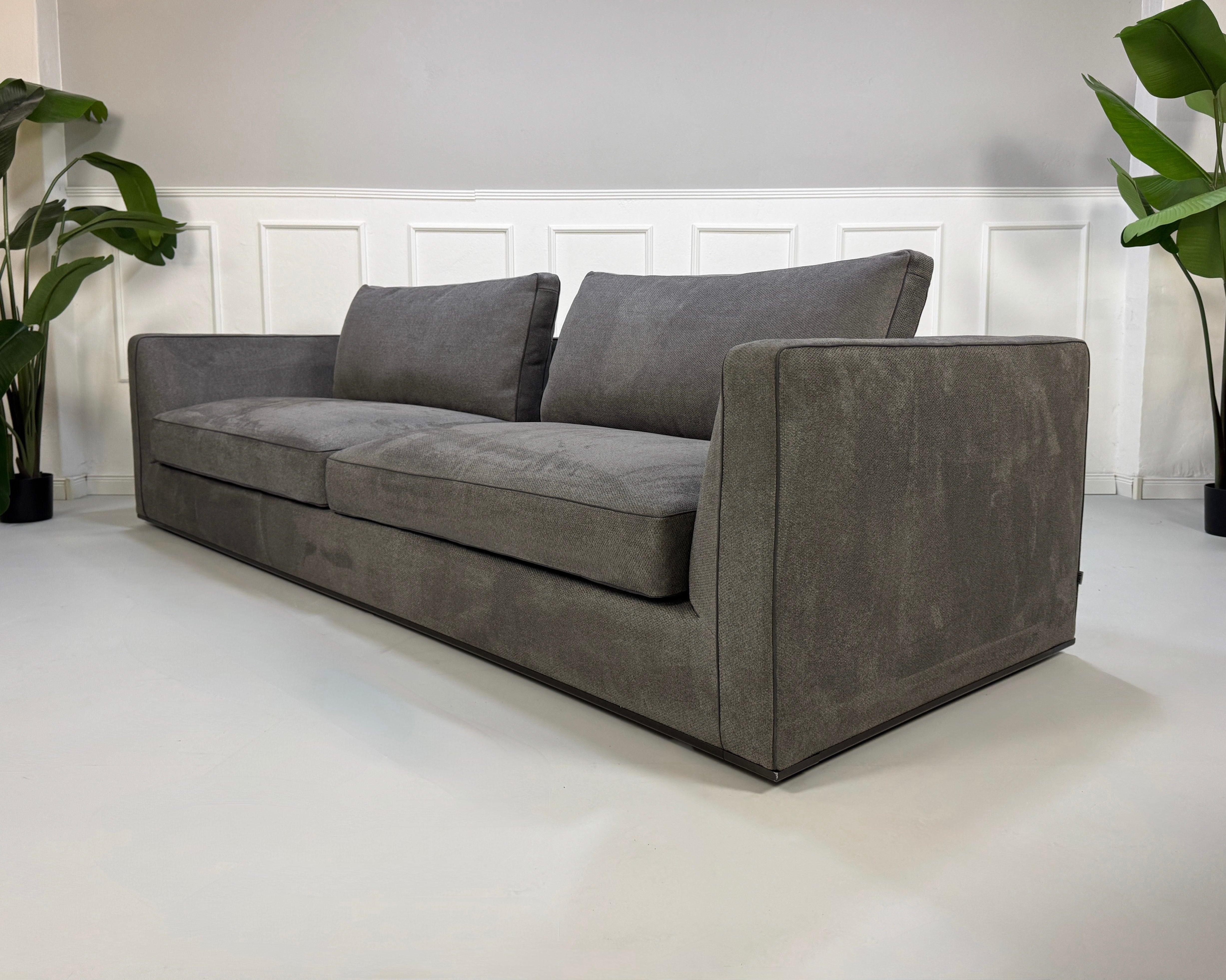 Gebrauchtes graues B&B Italia Richard Designer Stoff Sofa vor einer Wand, stilvoll und modern eingerichtet.