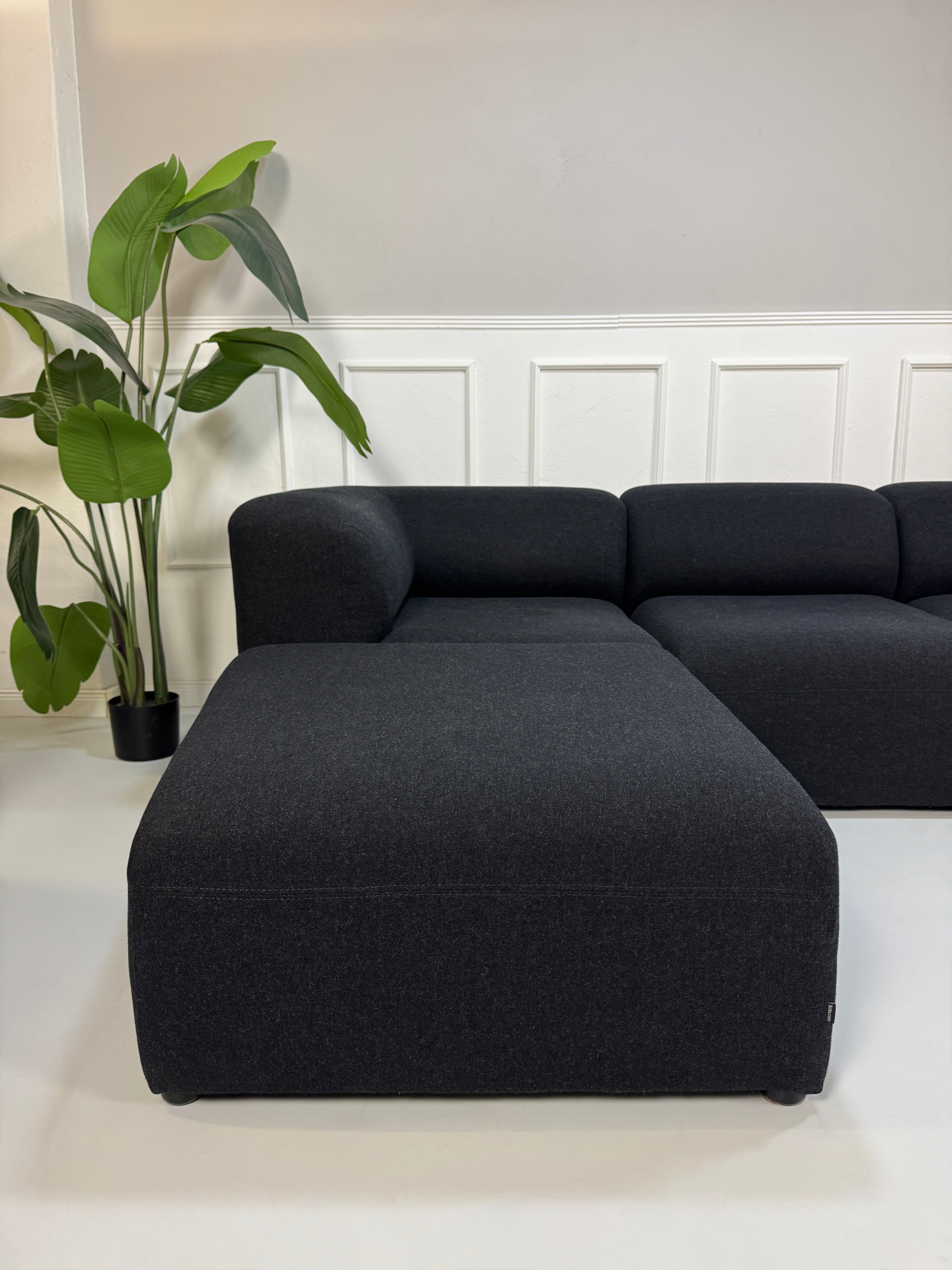 Gebrauchtes Bolia Angle Designer Stoff Sofa in der Farbe Schwarz vor einer Wand, stilvoll und modern eingerichtet.