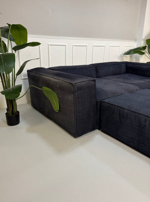 Gebrauchtes blaues Bolia Cosima Designer Stoff Sofa vor einer Wand, stilvoll und modern eingerichtet.