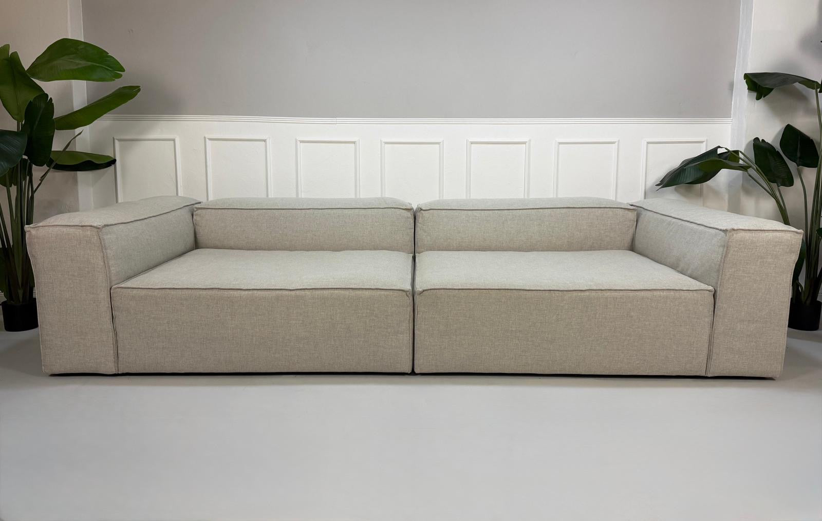 Gebrauchtes graues Bolia Cosima Designer Stoff Sofa vor einer Wand, stilvoll und modern eingerichtet.