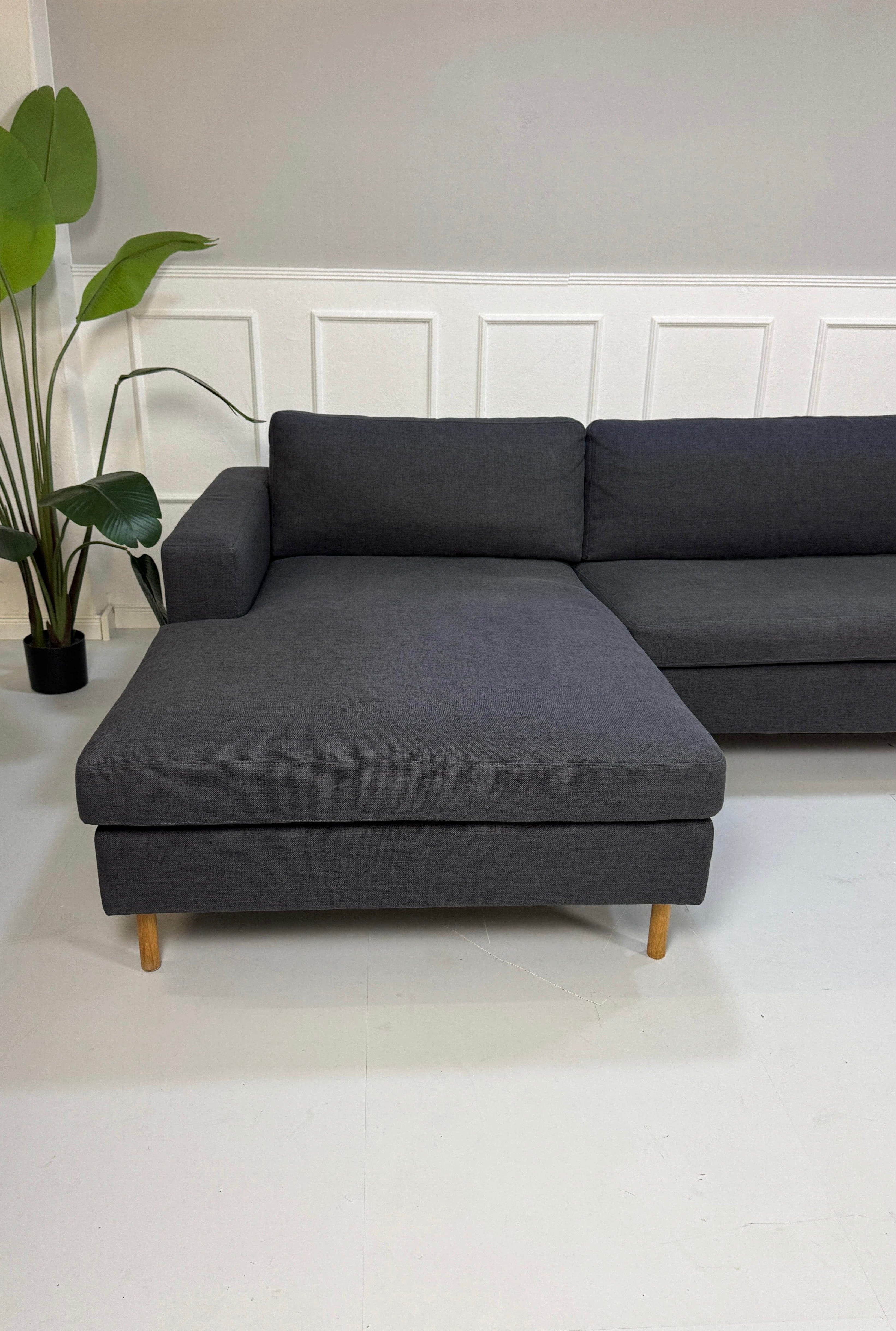 Gebrauchtes lila Bolia Scandinavia Designer Stoff Sofa vor einer Wand, stilvoll und modern eingerichtet.