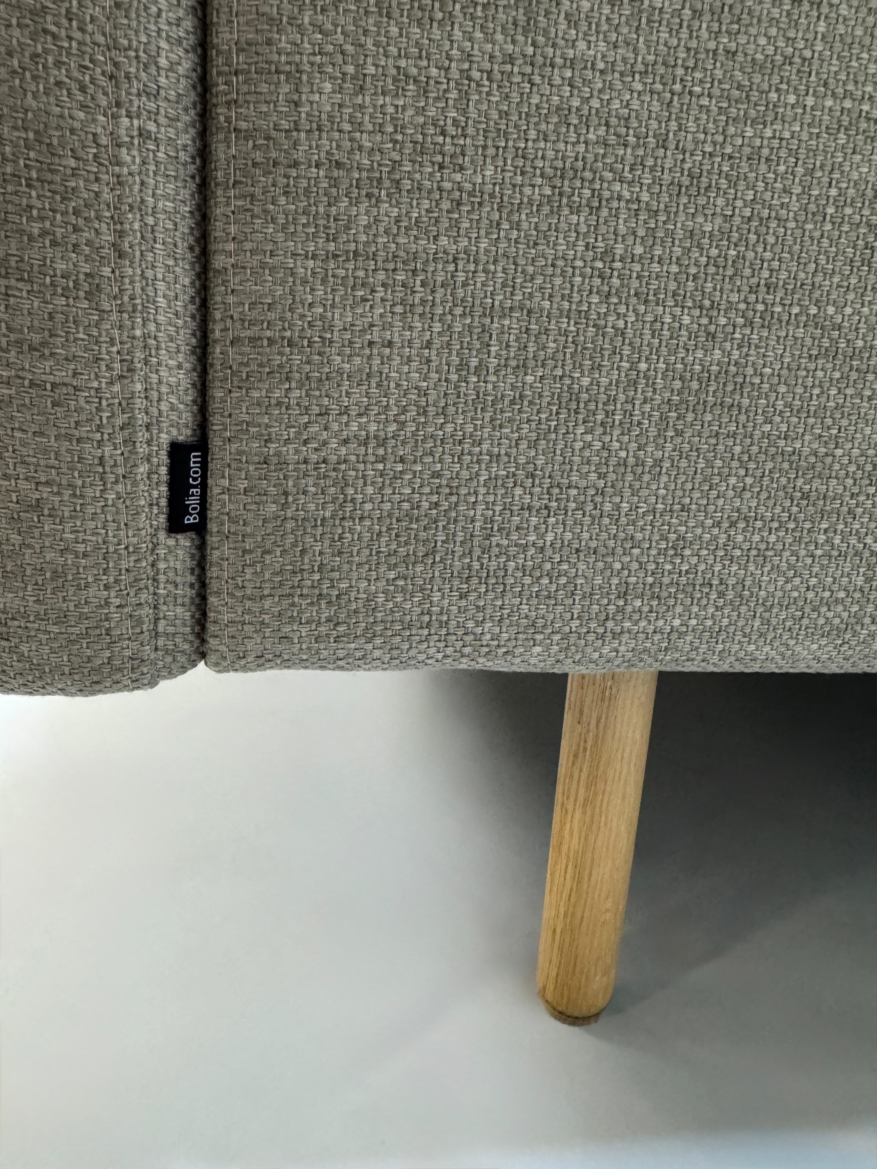 Gebrauchtes graues Bolia Remix Designer Stoff Sofa vor einer Wand, stilvoll und modern eingerichtet.